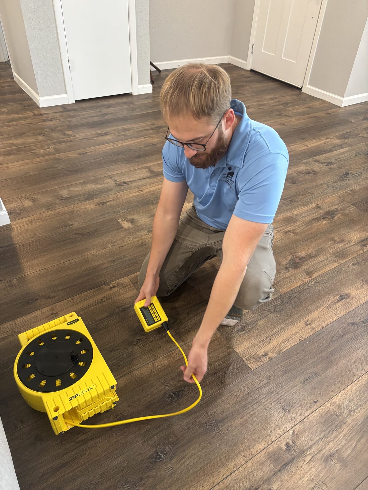 Measuring floor elevations with a zip level during a Dallas-Fort Worth foundation inspection