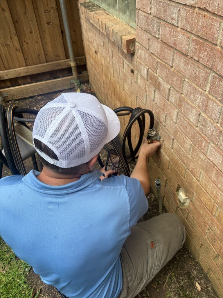 Home inspector inspecting exterior mechanical and plumbing connections at a Dallas-Fort Worth home - Buffalo Property Inspections